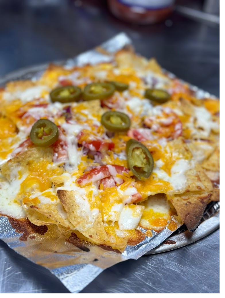 Loaded nachos with cheddar, mozzarella, tomato and jalapeños